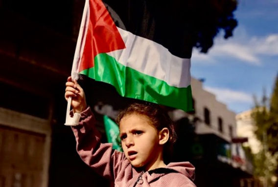 Girl with Palestinian flag in al-Khalīl; Image credit: Al Jazeera